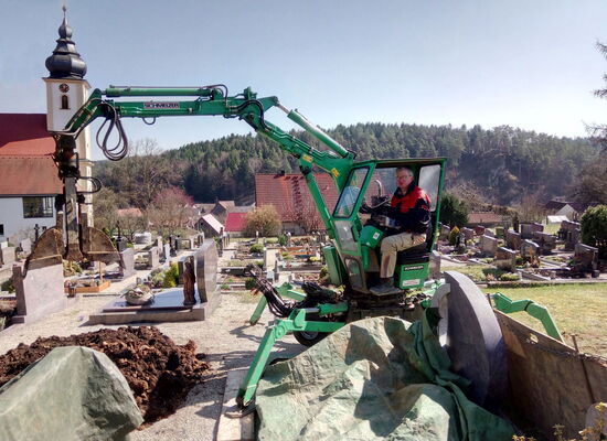 Grabaushub mit speziellem Friedhofsbagger für eine Erdbestattung am Friedhof in Nankendorf